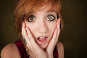 Shocked young girl on a green background