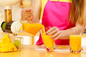 Woman pouring orange juice drink in glass