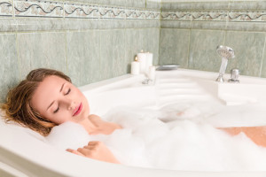 Young beautiful woman relaxing in a bath